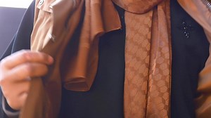 Download Close-Up of Person Zipping Brown Jacket Outdoors on a Cool Day for free