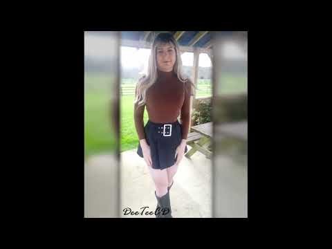 Crossdresser in Short Skirt and Knee Boots on a Windy Day