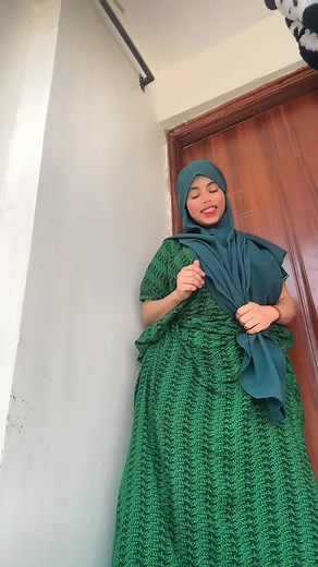 Stylish Green Dress and Teal Hijab Poses in Doorway