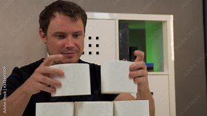 a man builds on the table a pyramid of toilet paper