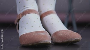 Little fidget girl in cute shoes playfully stomping her legs awaiting parents Stock Video