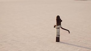 Rusty old metal water pump on sand beach