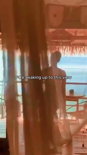 Walking Into a Dream View. A woman steps onto a wooden balcony overlooking bright tur...