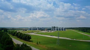 Modern factory among fields. Grain elevators for keeping agricultural products. Grain storage tank in the countryside. Aerial view