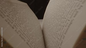 Probe lens floating over a book that is being opened. The book is an 1830 Book of Mormon and floating over the book of Alma