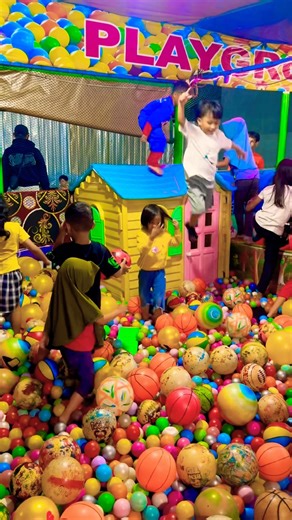 Sitting on blue roof of small house jumping into a pile of colorful balls ball pool ride exciting