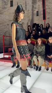 No brand understands the importance of a good location like #LouisVuitton. Last year, the Maison chose Barcelona’s Park Güell by Antoni Gaudí to host its Cruise collection. Tonight, the Cruise 2026 reveal took place at the Palais des Papes, a UNESCO World Heritage site in Avignon, France. The marvel of Gothic architecture set the throne for a collection of high drama, and next to the runway, guests sat on wooden thrones, upholstered in red velvet. At the sound of Excalibur, models wore looks ins