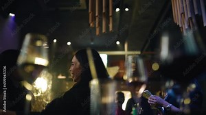 Three girlfriends at a party at the club. They're in a great mood. Shooting through glasses on the table