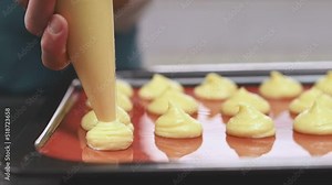 Chef prepares classic french cheese puffs in the kitchen. Female hands squeeze the dough from piping bag onto baking tray. Stock Video