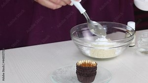 A woman makes candy from marzipan. Mixes almond flour, icing sugar and water. Close-up shot.
