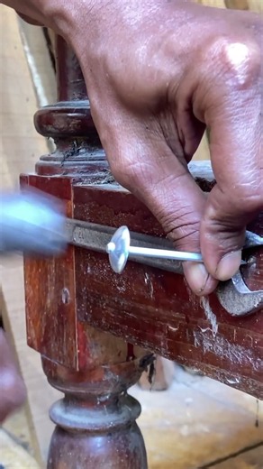 using a ring spanner to tighten the wood connection.