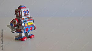 Metal wind up robot toy with walks from the left to the center of the screen very slowly. Full HD 1080p. Still frame. Stock Video