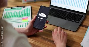 Cloud loading concept on phone screen. Woman is holding phone in hands performing cloud upload