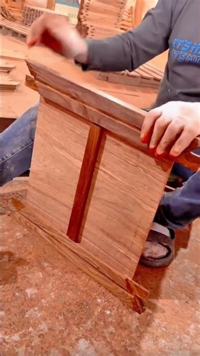 Woodworker taps wooden joint fitting spline into panel assembly