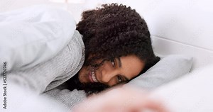 Woman, portrait and bedroom with shy hand gesture to hide face from person in the room. Cute and tired girl resting on pillow for nap to relax at home with embarrassed and playful smile.
