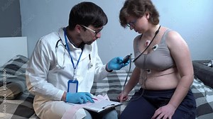 Home healthcare visit. Doctor visiting unhealthy woman. Doctor consults patient. Woman cardiac patient at home with doctor. Patient care. Diagnostics. Appointment at home. Cardiology diseases