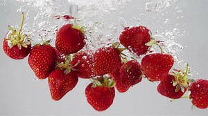 A bunch of strawberries falling through water - Free Stock Video