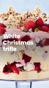 This pretty-in-pink trifle is filled with sponge, jelly, custard, Raffaello chocolates, raspberries and white Christmas stars. For the recipe, Google 'Taste White Christmas trifle'. Recipe by Lucy Nunes #trifle #christmastrifle #triflerecipe #trifle #christmasrecipes #christmasrecipe | Taste.com.au