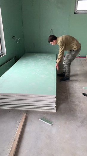 Installing Light Green Wall Panels in Room Renovation