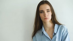 Professional fashion model posing and looking into camera. Woman show poses and emotions closeup