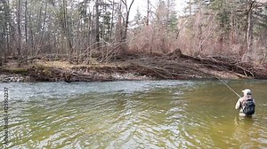Fisherman catches of grayling in the river in the morning