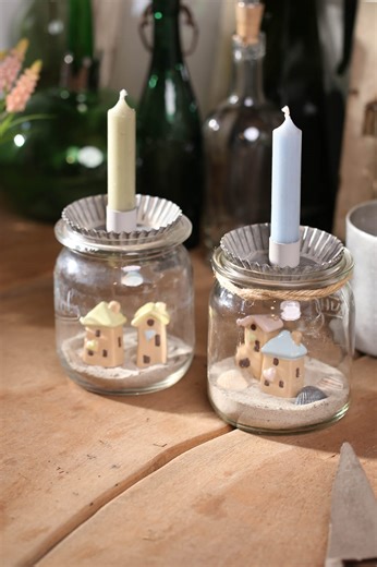 Weckglas Dekoidee 🩷 Mit alten Einmachgläsern kann man ganz einfach tolle Dekorationen gestalten. Wir haben zwei kleine Gläser mit Sand gefüllt und die niedlichen Mini Häuschen in Pastellfarben rein gesetzt. Dazu die kleine Backform als Deckel und die raffinierten magnetischen Kerzenhalter oben drauf. Wir lieben die Pastellfarben für den Frühling und kombinieren gerne verschiedene Kerzenfarben. 💚💐 Lust deine alten Einmachgläser so zu Dekorieren? Bei uns im Onlineshop findest du alle verwendete