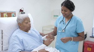 Nurse helps female patient with flow meter in hospital patient room