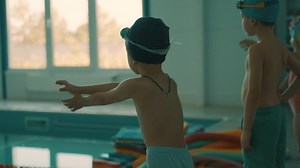 Chernivtsi, Ukraine - August 2, 2022: Swimming lessons. Training by the pool. Children warm up and do exercises before swimming. Young swimmers. A healthy active lifestyle.