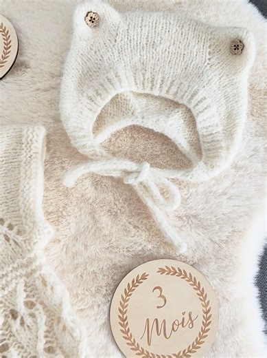 Ensemble naissance tricoté main - Gilet & Béguin à oreilles Magnifique ensemble fait main pour bébé (taille 1-3 mois), idéal pour un cadeau de naissance ou pour garder bébé bien au chaud avec style. Détails du produit : Composition : Laine de haute qualité Drops Air (65% alpaga, 28% polyamide, 7% laine). C'est une laine extrêmement douce, légère et qui ne pique pas. Comprend : Un petit gilet sans manches avec boutons en bois et un béguin assorti avec de mignonnes petites oreilles. Couleur : Écru