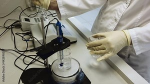 Analytical laboratory. Mixing of the solution. Adding substance to the solution. Adding a transparent reagent.