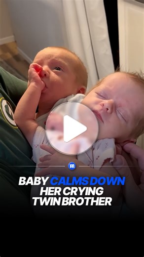 Baby gently comforts crying twin in sweet moment