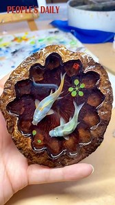A Chinese resin painter gives a dried-up lotus seedpod new life with his ingenious brushes. | People's Daily, China