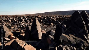 Capture the slow formation of hexagonal basalt lava columns at a remote volcanic site, showing the geometric beauty created by natural forces. Stock Video