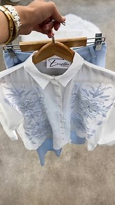 Look frais & élégant pour vos journées estivales �� On adore cette chemise blanche à manches longues, délicatement brodée de motifs floraux en perles et fils bleus – un vrai bijou de douceur et de raffinement �� Taille : standard Associée à un pantalon large couleur bleu ciel, au tissu fluide et satiné, pour une allure chic et confortable à la fois � Tailles disponibles : 36/38/40/42 Un ensemble parfait pour un style à la fois moderne, féminin et léger � � À porter avec des baskets blanches pour
