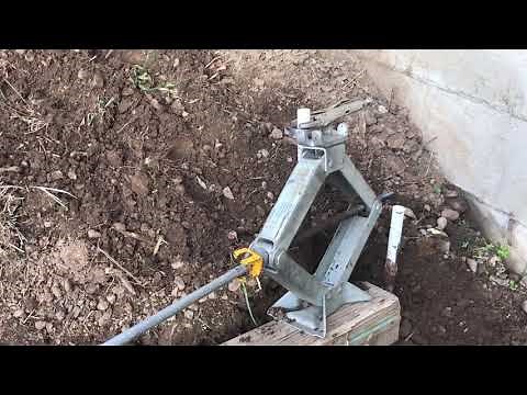 Removing iron stakes from ground with scissor jack