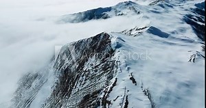 Snow mountain Aerial landscape peak of Mount Siguniang at Sichuan China with mist floating under blue sky ,camera tilt up