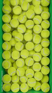 Looping 3D animation of falling tennis balls filling the screen and dropping away