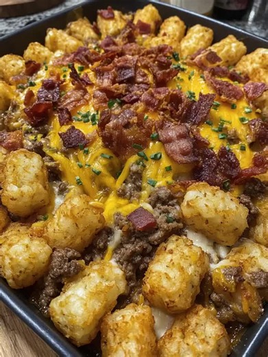 Recipe Name: Loaded Bacon Cheeseburger Tater Tot Casserole Ingredients 1. 1 bag (32 oz) frozen tater tots 2. 1 lb ground beef 3. 8 slices bacon, cooked and crumbled 4. 1 small onion, diced 5. 2 cups cheddar cheese, shredded 6. 1 cup mozzarella cheese, shredded 7. 1 tsp garlic powder 8. 1 tsp onion powder 9. 1 tsp salt 10. ½ tsp black pepper 11. 2 tbsp chopped chives 12. 1 tbsp olive oil Recipe 1. Preheat oven to 400°F (200°C). 2. Heat olive oil in a skillet over medium heat. 3. Add onion and coo