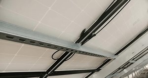 Handheld shot of modern photovoltaic panels. Connection cables behind the solar panels. Concept renewable energy, technology, electricity, service, green, future.