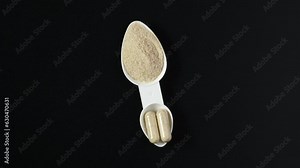 Psyllium husk powder vs Psyllium husk capsules in measuring spoon. 4K Video, Rotating. Comparison of different forms of natural dietary supplements for health.