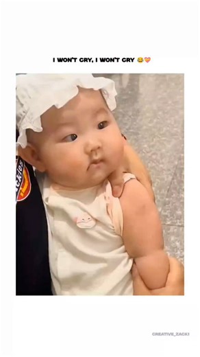 Creative Zack on Instagram: "The post shares a 10-second video of an Asian infant in a white hat and onesie grimacing and ultimately crying during an arm vaccination, captioned "I won't cry, I won't cry " to humorously capture the baby's resolve. From @wholesome_X_ , an account curating feel-good videos and images, it quickly amassed 83,000 views and 995 likes by December 27, 2025, tapping into universal themes of parental care and toddler resilience. Viewer responses blend tenderness—one callin