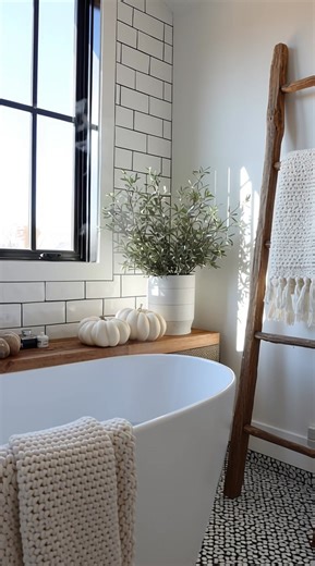Rustic ladder, black-trim window, and details that turn a bathroom into a statement. #FarmhouseLiving #FallDecorInspo | Prime Real Estate Inc.