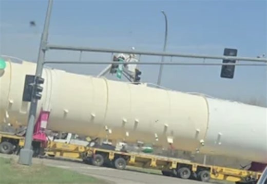 Boom truck worker thrown from bucket while trying to guide oversize load beneath traffic light