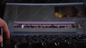 Close-up, computer keyboard, a man's hand clicks on the keys. On the monitor video editor. 4K Slow Mo