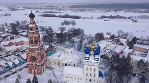 Scenic view from drone of temple complex of Cathedral of Archangel Michael and Church of Jerusalem Icon of Mother of God with Bronnitsy cityscape on background in winter, Russia