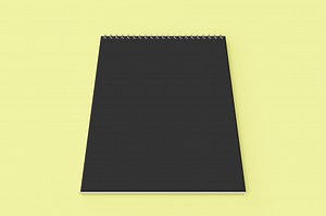 Blank black notebook with metal spiral bound on yellow background....