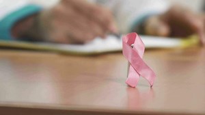Download Pink ribbon breast cancer awareness symbol on the table of a doctor for free