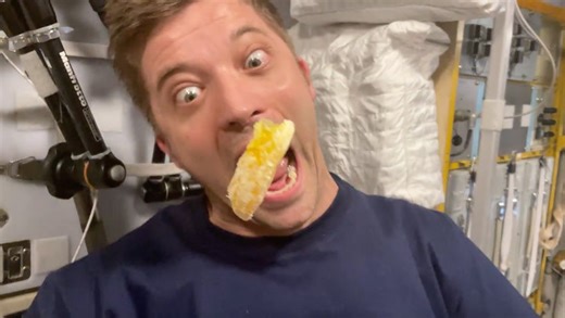 Slow motion video captures astronaut eating a slice of orange in space station