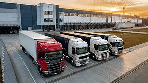 Smooth logistics at sunrise: truck convoy departs modern distribution center