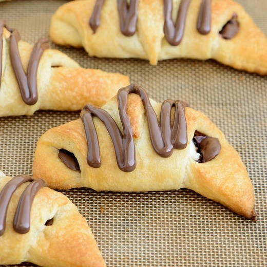 These Nutella Cream Cheese Crescent Rolls could not be easier. Filled with rich Nutella and chunks of cream cheese, topped with more Nutella, and only take 20 minutes to make! Get the recipe --> https://www.bakedbyanintrovert.com/nutella-cream-cheese-crescent-rolls/ | Baked by an Introvert